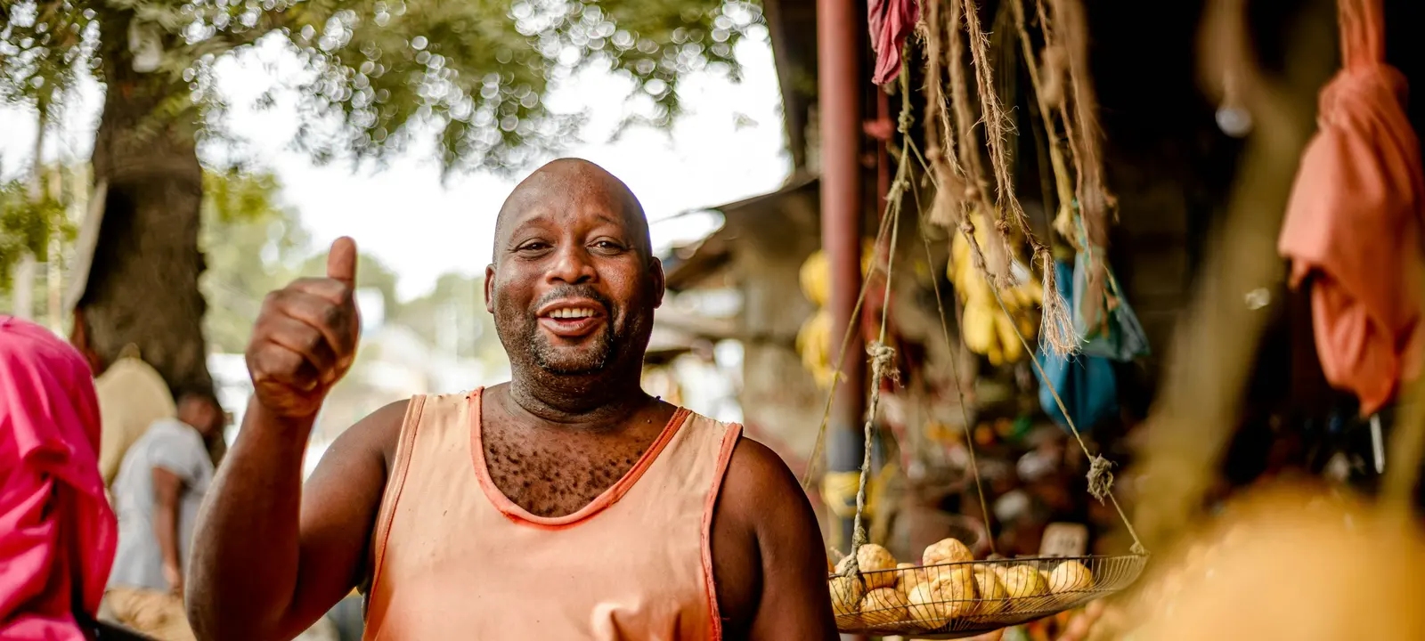 Vendedor sorridente numa banca de fruta de um mercado local
